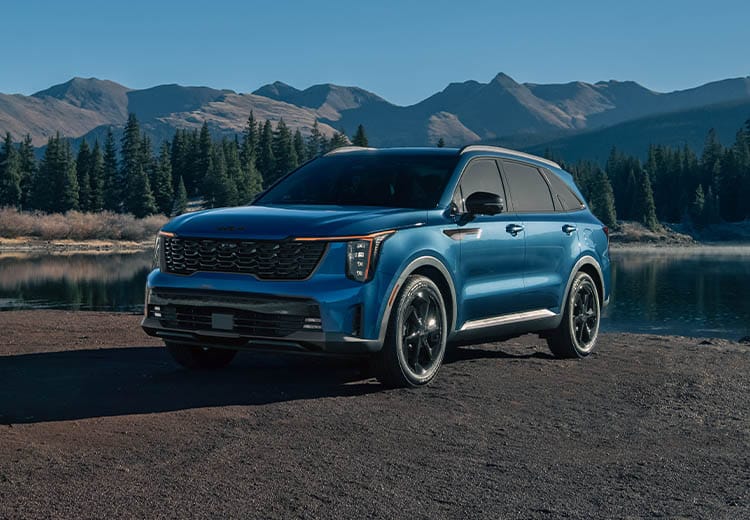 2026 Kia Sorento Hybrid in blue, three-quarter front view, parked in front of the mountains